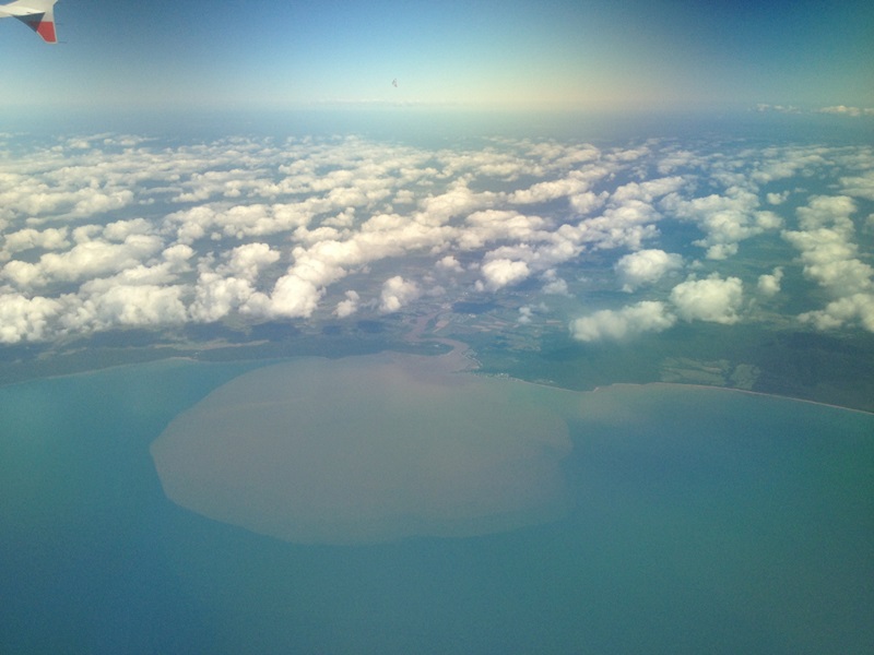 aerial view of coast with plume in water
