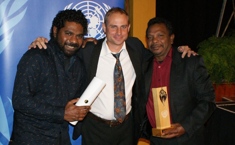 Three men holding an award
