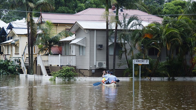 Two policemen in a canoe on a flooded street