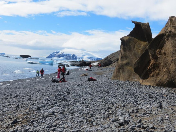 granite beach with ice-capped mountain in background