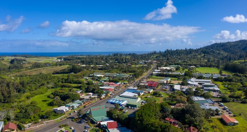 Aerial photo of a town on Norfolk Island with the ocean in the background