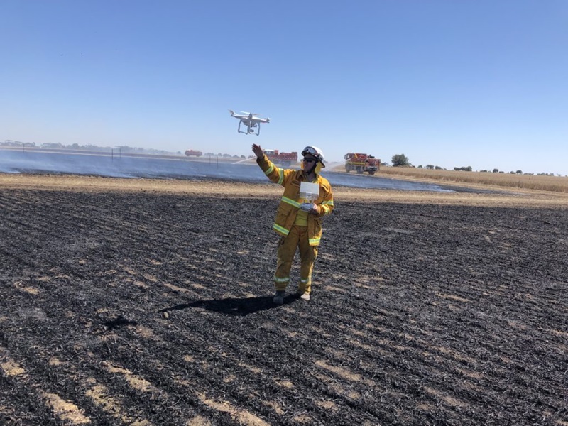 Man in a burnt field releasing a drone