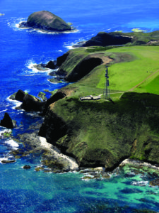 Aerial view of a tower on the edge of a seaside cliff