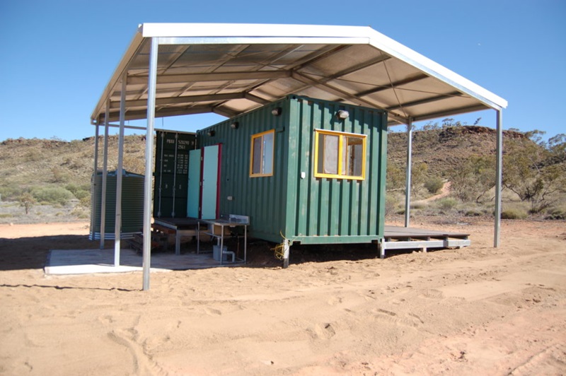 house made of a shipping container with a large roof over the top in a central Australian landscape 