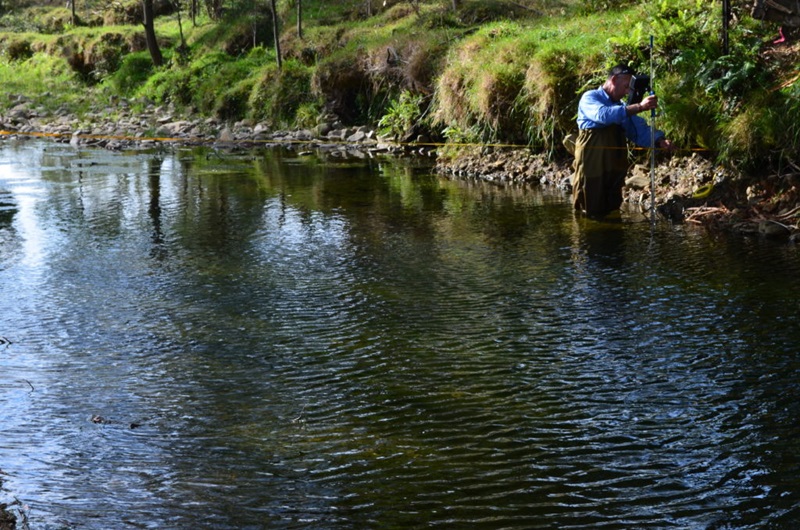 man checking instrument in river