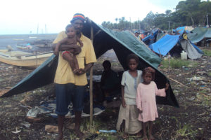 A family standing outside a makeshift tent