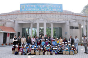A group posing for a photo in from of building with Ganga Aquarium sign