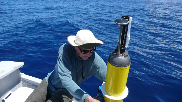 man in hat on boat with yellow buoy