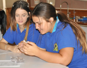 Two school girls in a school lab examining an object