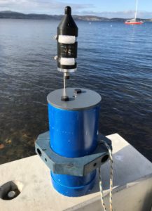 A blue cylinder with what looks like a black bottle on top. A hydrophone.