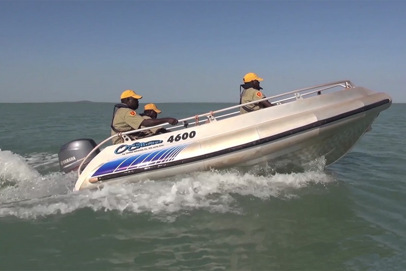 Three Indigenous rangers in a motor boat