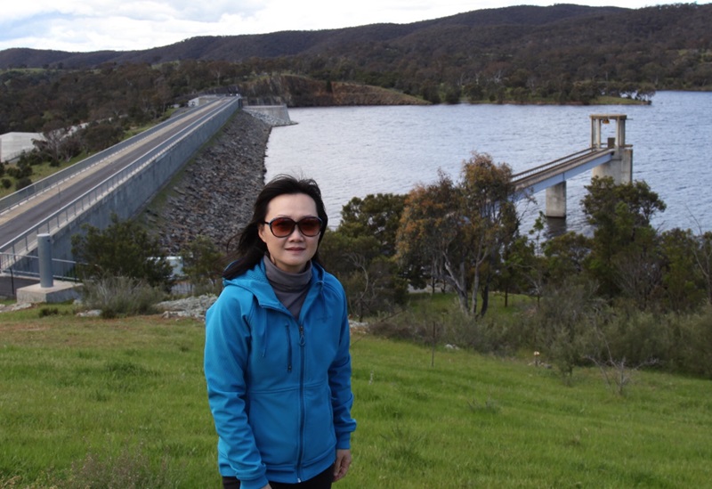woman with dam wall in background