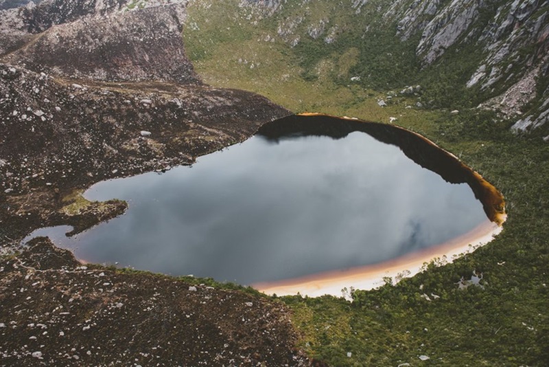 View of Lake Rhona in Tasmania's wilderness, showing discolouration and areas of fire damage.