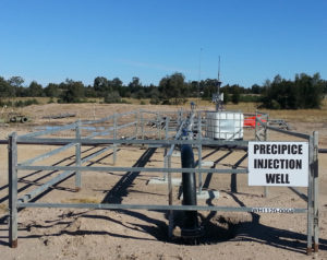 A large pipe fenced off going into the ground