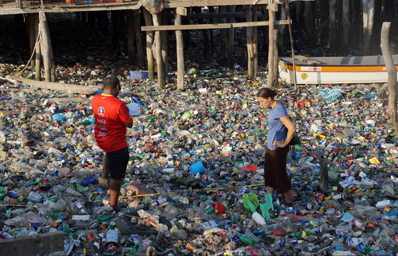 people standing in a sea of plastic in a waterway