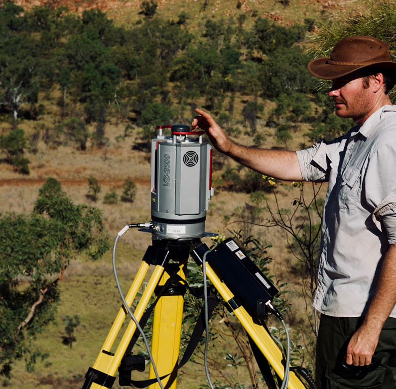 man with laser equipment in bush