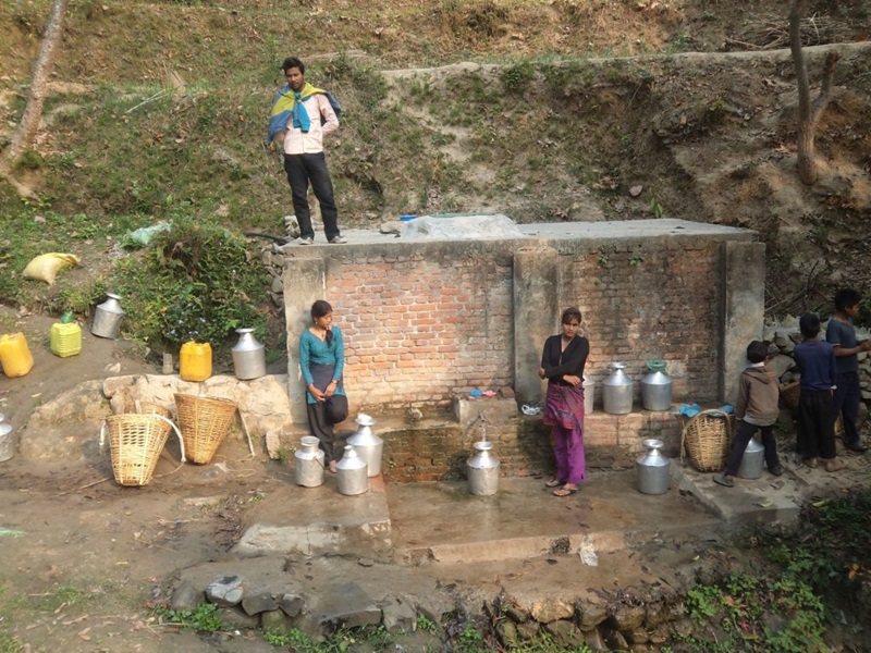 People from teh village gathering water from a groundwater source
