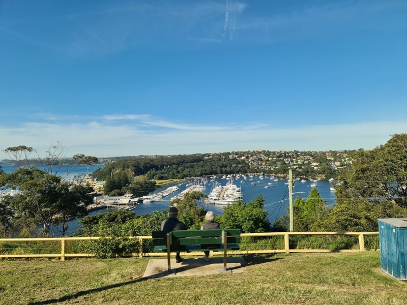 two people sitting on a bench overlooking the bay in Sydney - urban greening
