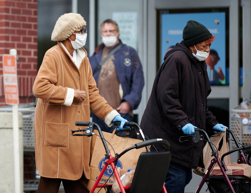 Picture of elderly women with walking frames and masks and gloves on. The women are grocery shopping in Richmond, Virginia. April 2020. Image by Ronnie Pitman/Flickr 