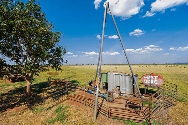 A water bore surrounded by a metal fence