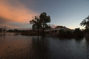 flood waters surround a home at sunset