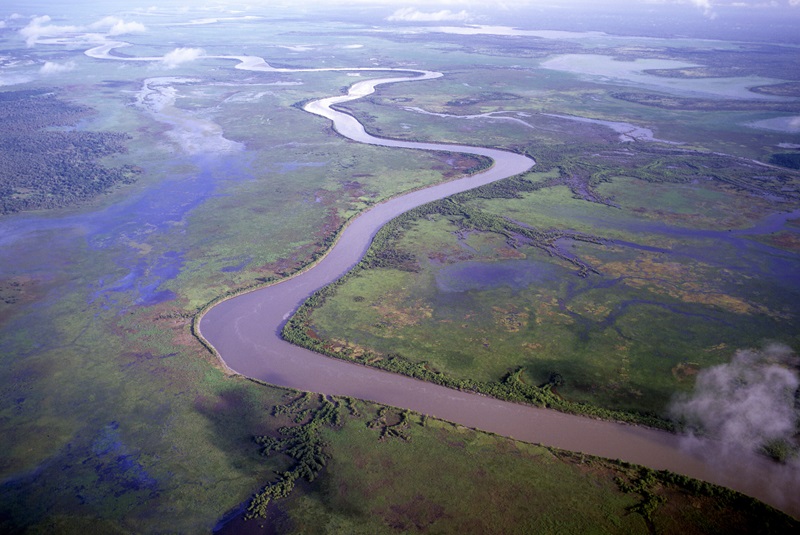aerial of river winding through coastal flood plain