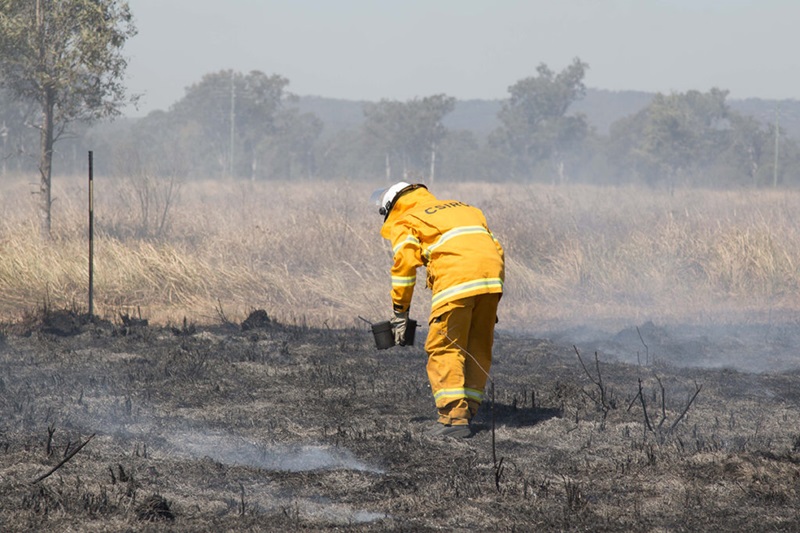 Person in yellow suit on burnt grass