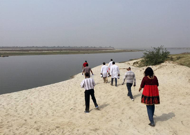 A group of scientists walking alongside a canal.