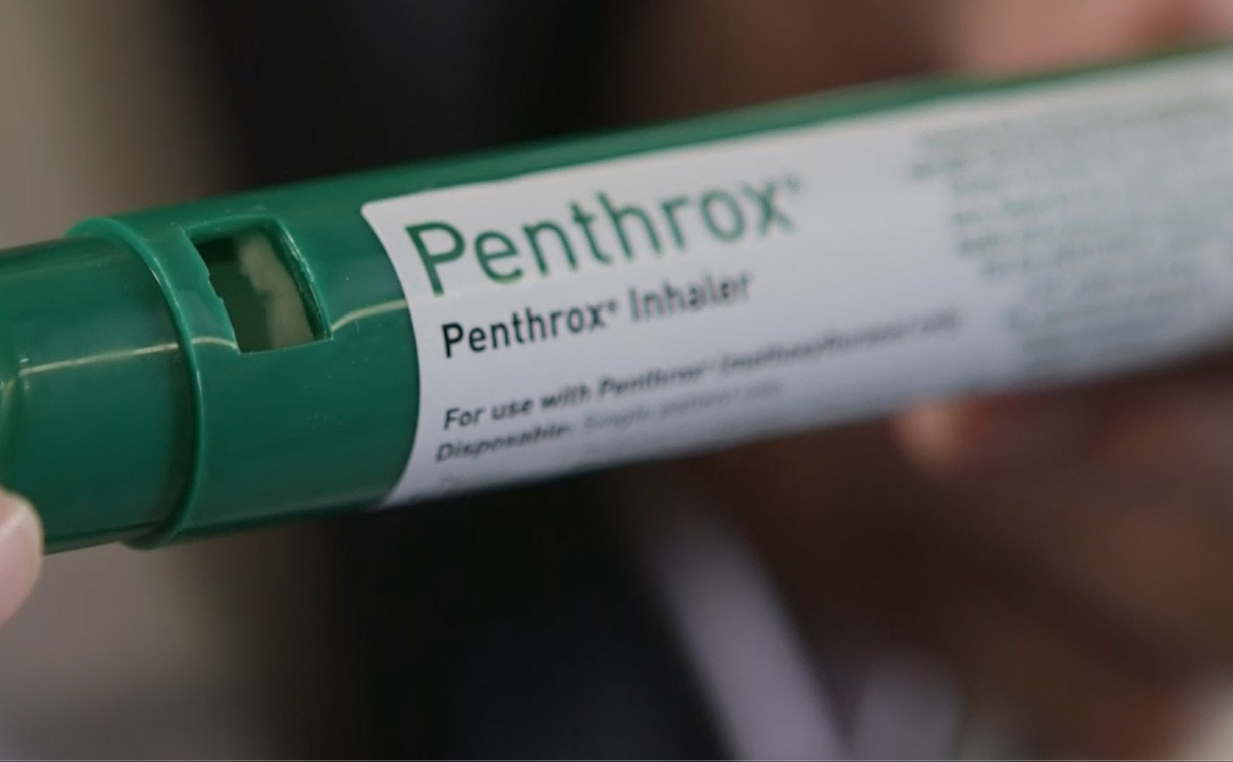 Hand holding Penthrox inhaler.