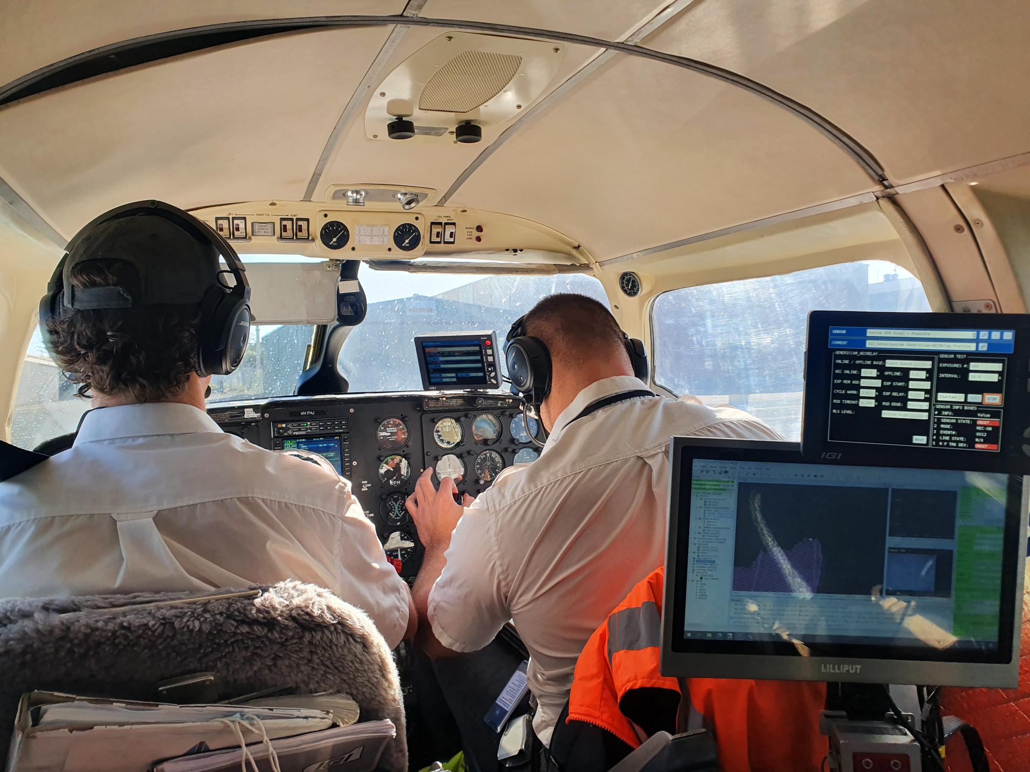 Pilots operating an aeroplane with LiDAR sensors attached. The plane was flown over the region. These sensors are a remote sensing method used to collect accurate digital elevation models for the region for hydrodynamic modelling.