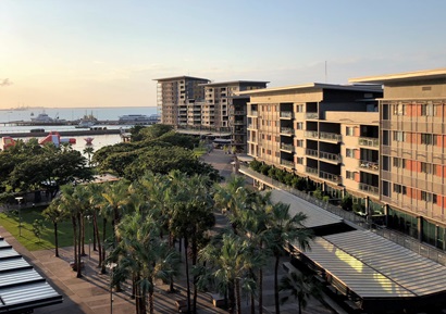 view of waterfront development with palm trees in the foreground and multistory apartments 